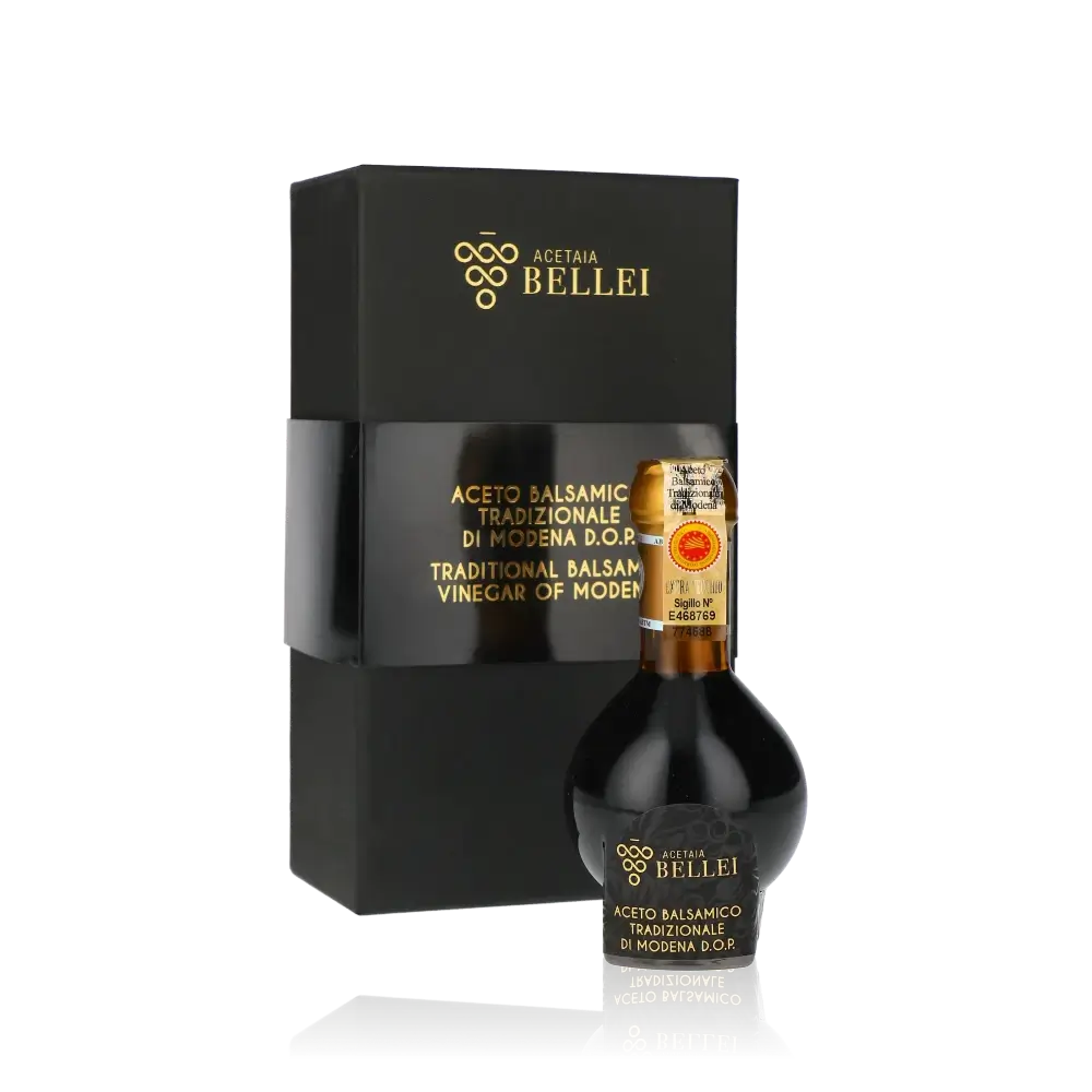 Aceto Balsamico Bellei Flasche und Verpackung vor schwarzem Hintergrund.