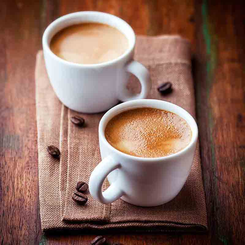 Zwei Tassen Kaffee auf Tisch.