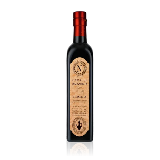 Flasche Cavalli Balsamessig mit rotem Verschluss auf schwarzem Hintergrund.