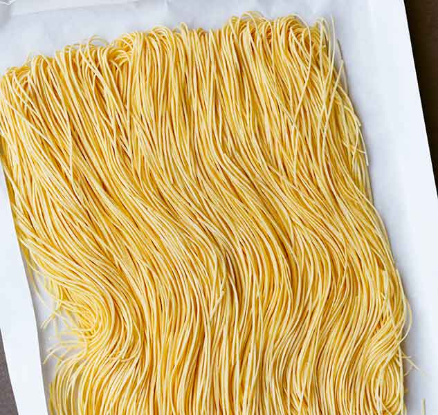 Frische, ungekochte Spaghetti auf Tablett.