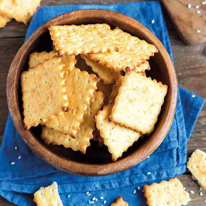Knusprige Delser Cracker in einer Holzschale auf blauem Tuch.