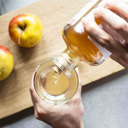 Dr. Höhl's Apfelessig wird in ein Glas gegossen.