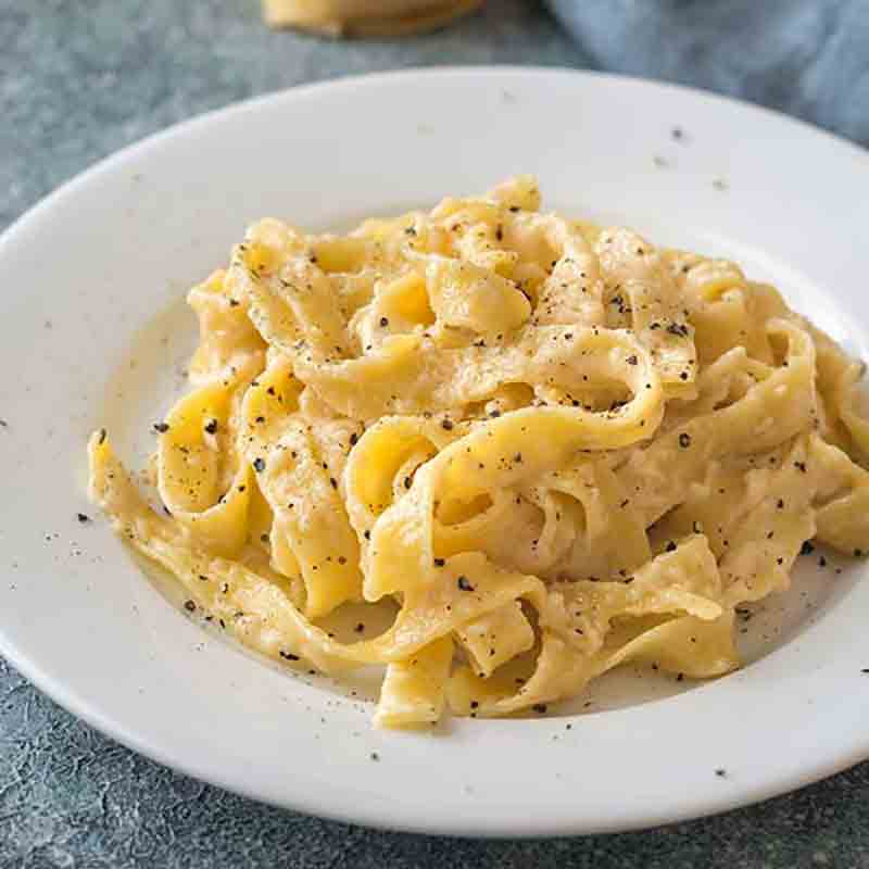 Fettuccine auf Teller mit Pfeffer bestreut.