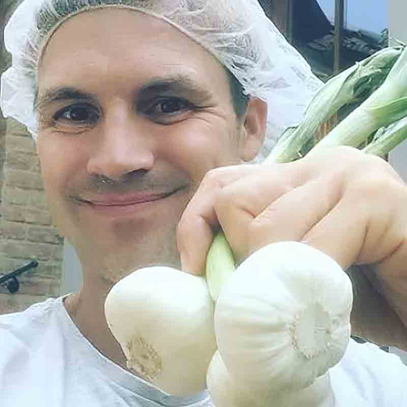 Person mit Knoblauch und Lauch.