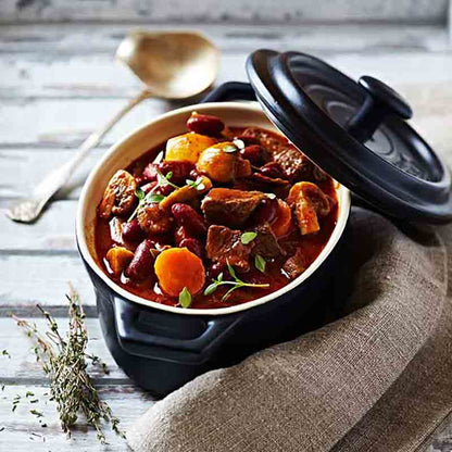 Gulasch in schwarzem Topf serviert.