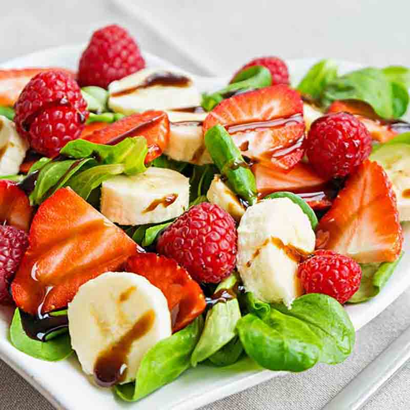 Salat mit Himbeerbalsam, Erdbeeren, Bananen und Himbeeren.