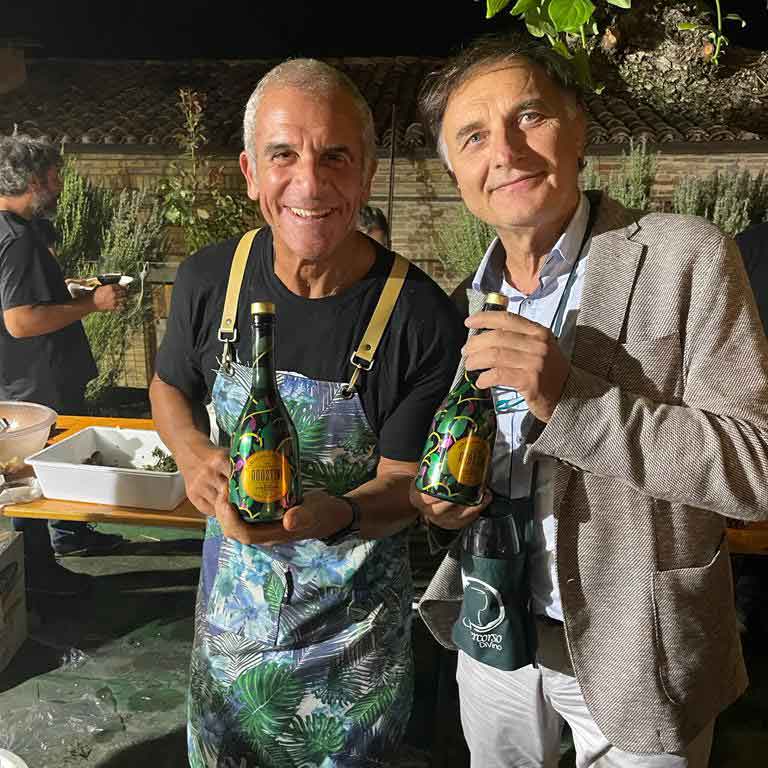 Familie Agostini hält eines Ihrer Olivenöle auf einer Gartenparty in der Hand