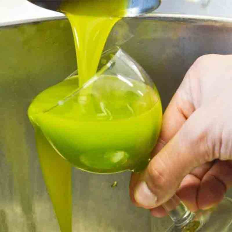 Olivenöl wird in ein Glas gegossen.