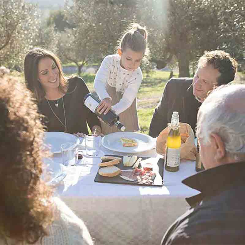Die Inhaber-Familie Gradassi beim Essen in den Olivenhainen.