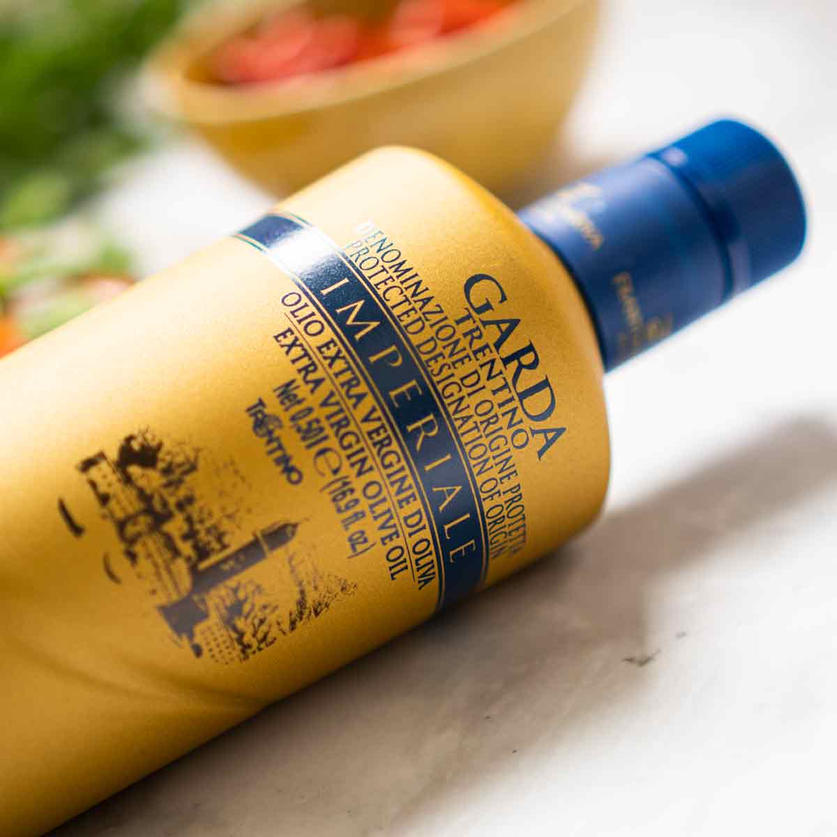 Olivenölflasche "Garda Imperiale" auf Tisch liegend.