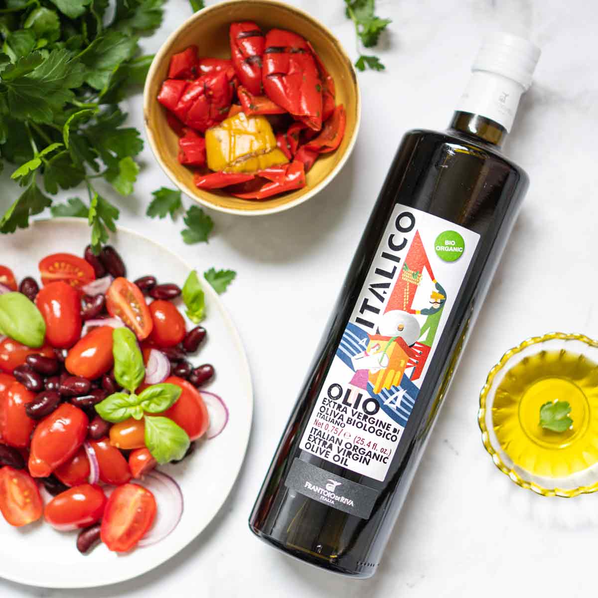 Olivenölflasche Italico neben Salat und Paprika.