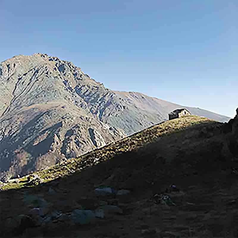 Berglandschaft mit kleinem Steinhaus.