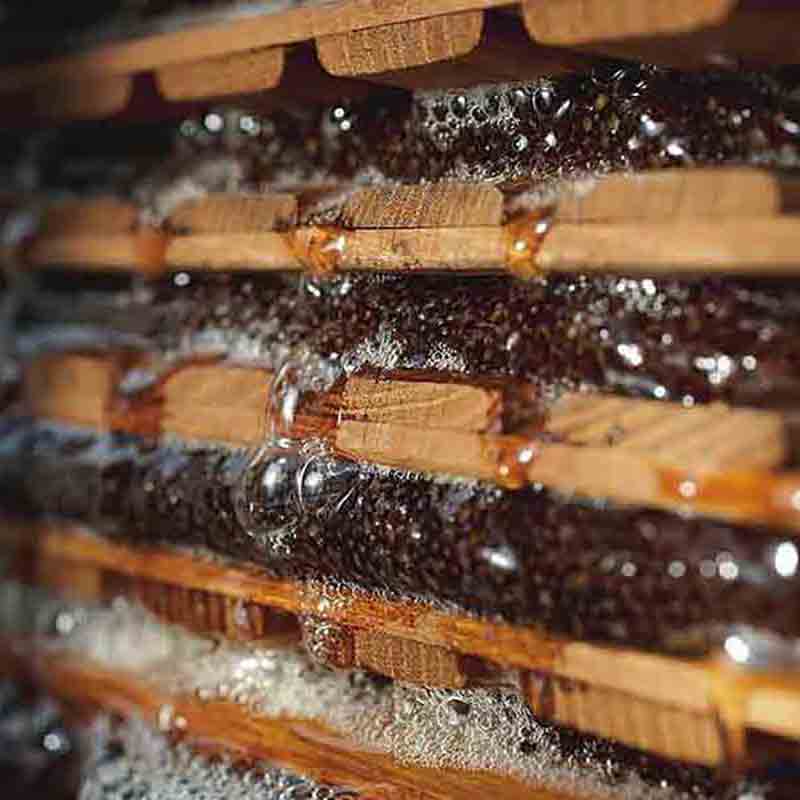 Apfelpressvorgang mit Holzplatten.