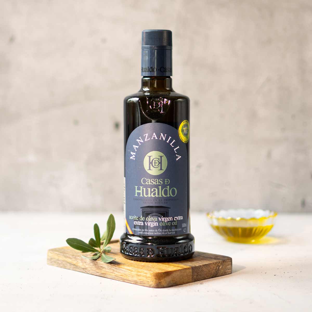 Flasche Casas de Hualdo Manzanilla Olivenöl auf Holzbrett.