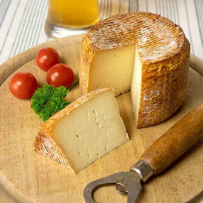 Käse mit Bier, Tomaten, Petersilie, Korkenzieher auf Holzbrett.
