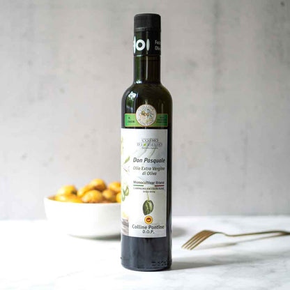 Olivenölflasche Don Pasquale vor Schüssel mit Oliven.