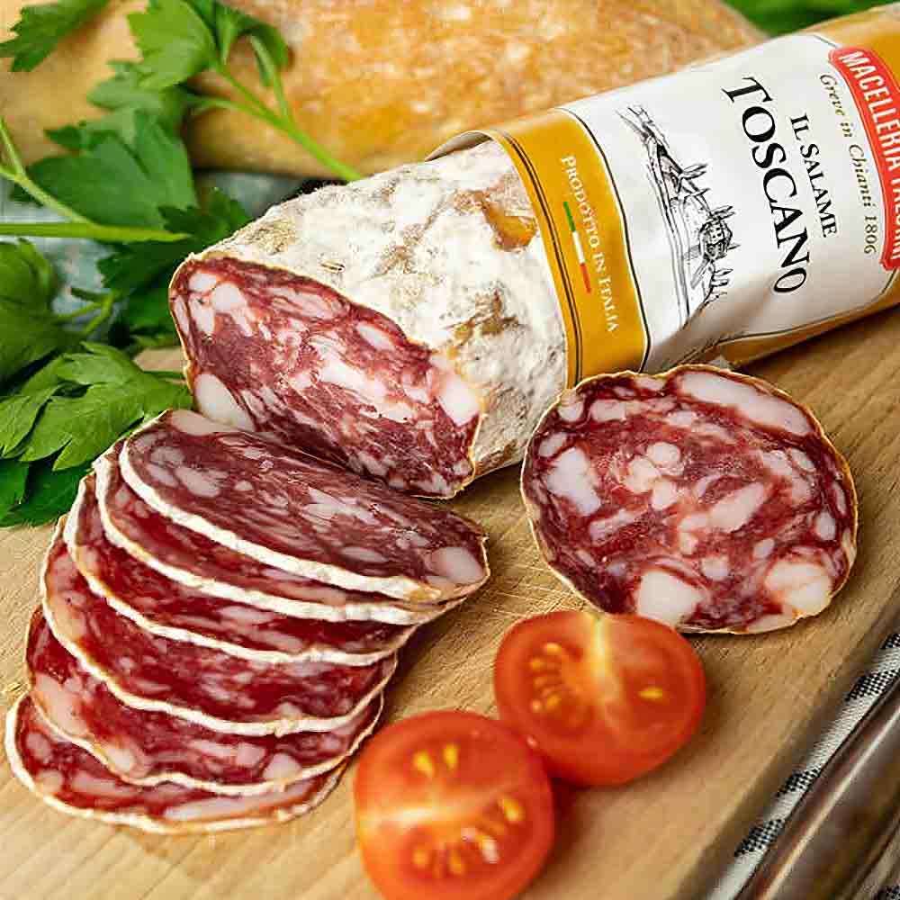 Salami, geschnitten, mit Tomaten und Petersilie auf Holzbrett.