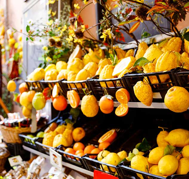 Zitronen und Orangen in Körben auf Marktstand ausgestellt.