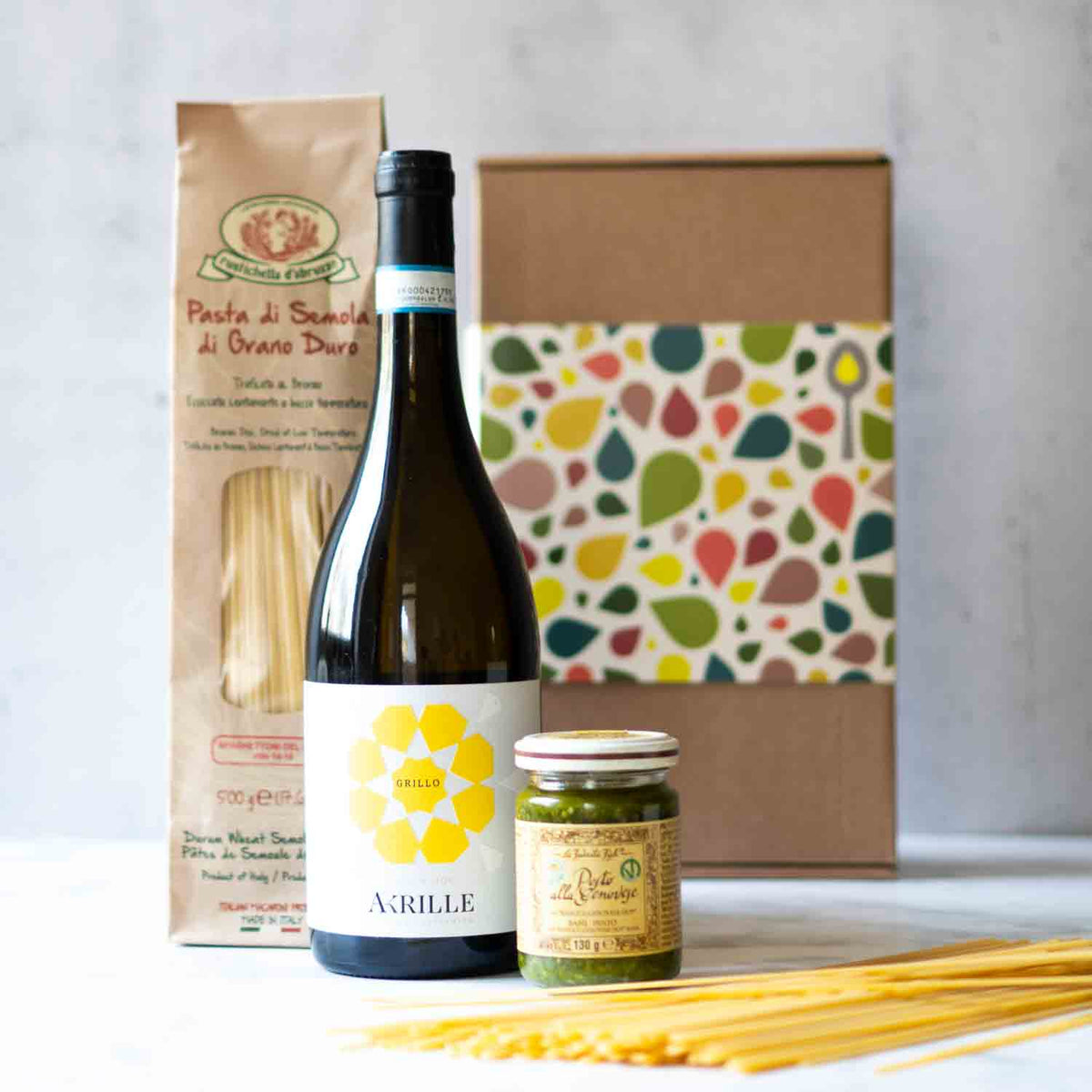 Wein, Pasta, Pesto, Geschenkbox mit buntem Muster.