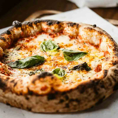 Pizza Napoletana im Tomaten, Mozzarella und Basilikum.