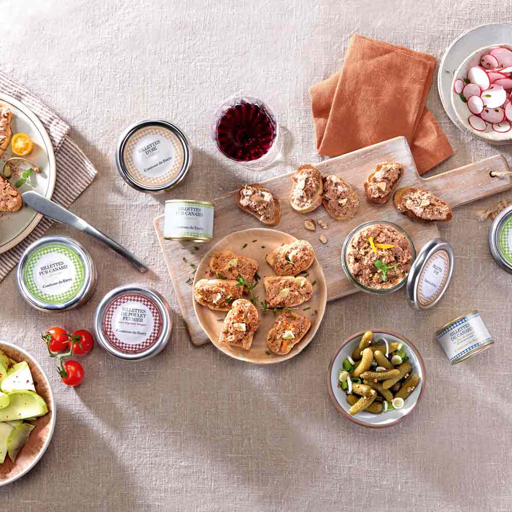 Verschiedene Feinkostprodukte und Wein auf einem Tisch arrangiert.