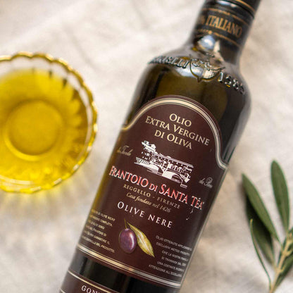 Flasche Frantoio di Santa Tea Olivenöl mit Olivenzweig.