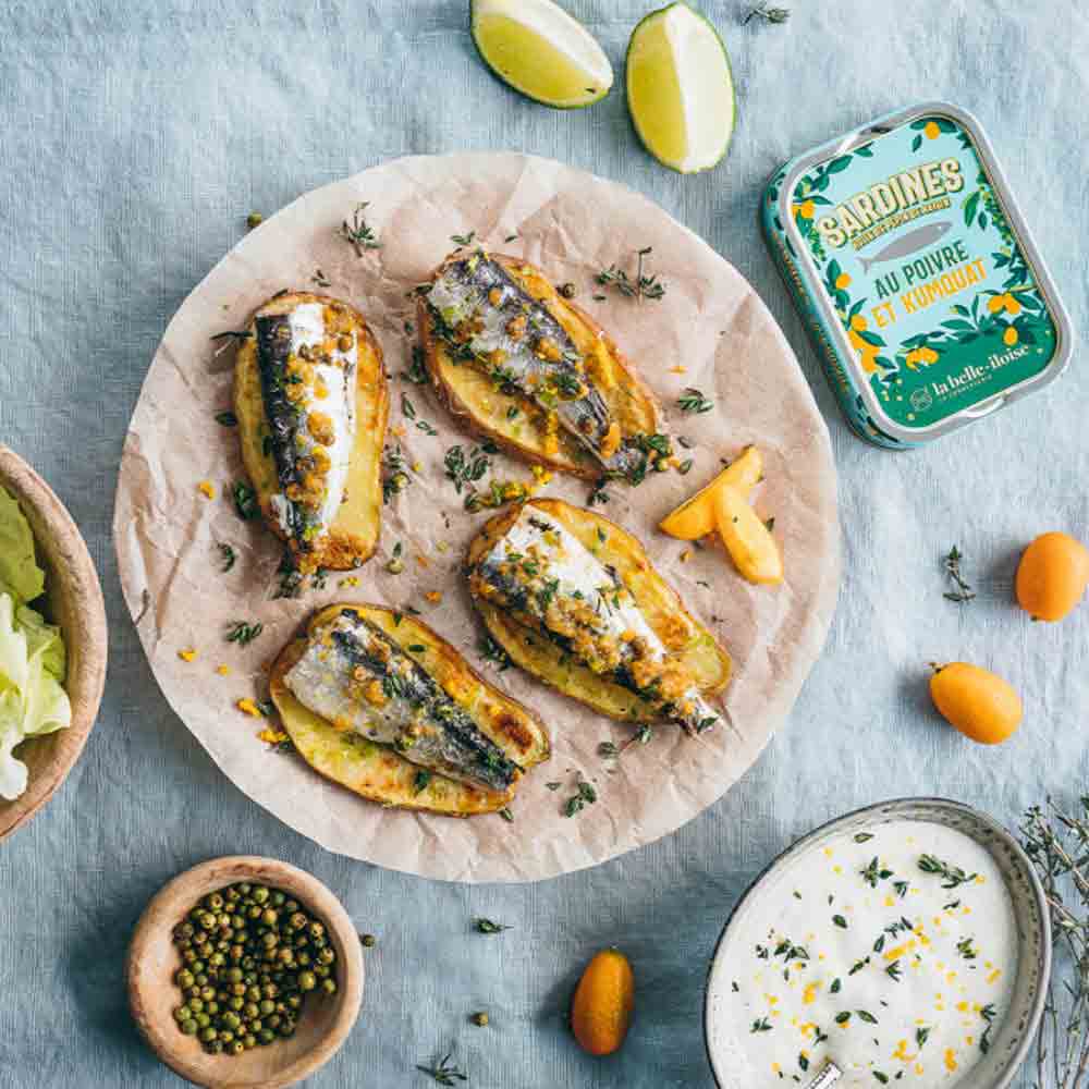 Sardinen mit grünem Pfeffer und Kumquat auf Teller.