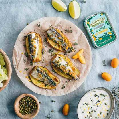 Sardinen mit grünem Pfeffer und Kumquat auf Teller.