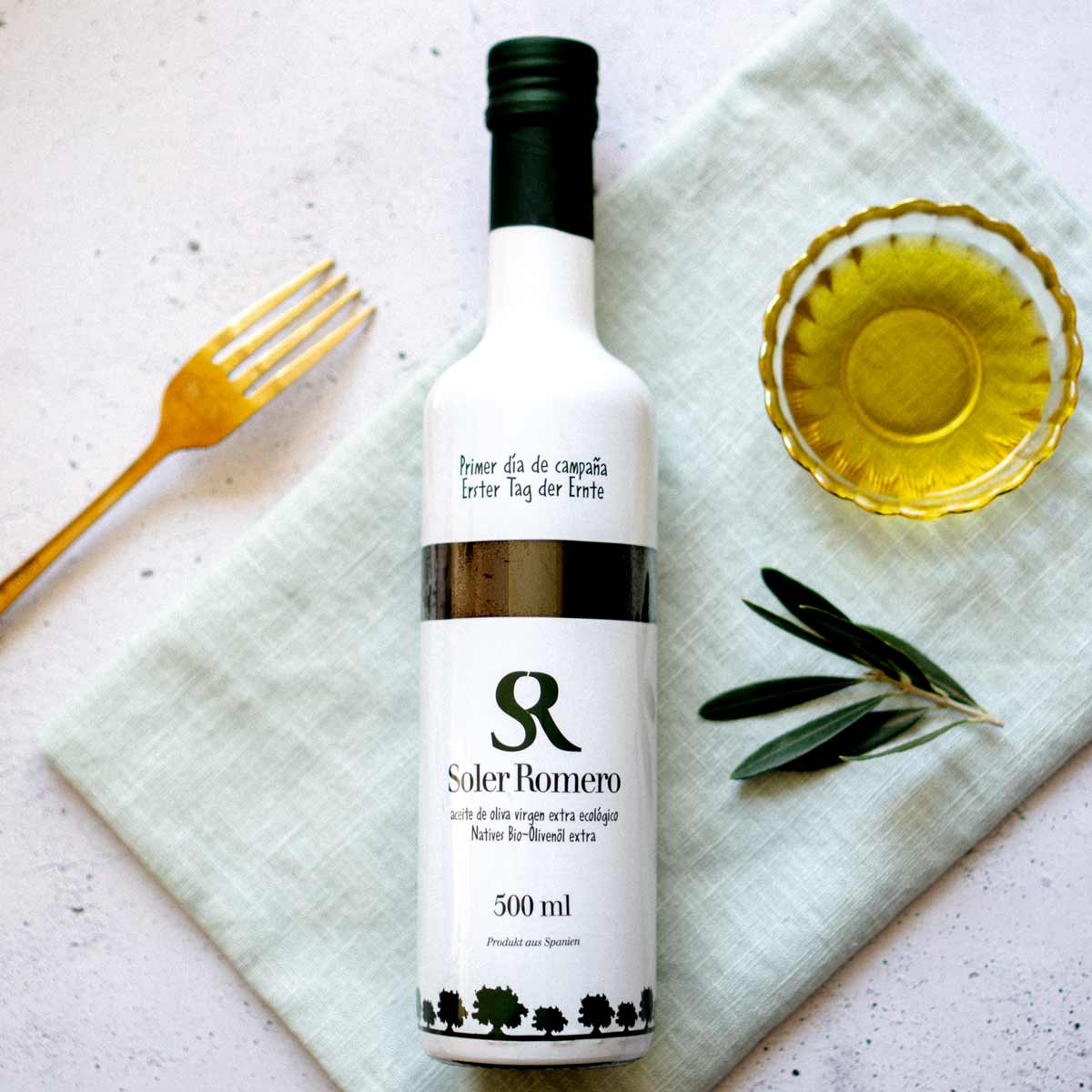 Soler Romero Olivenölflasche mit Olivenzweig und Schale.