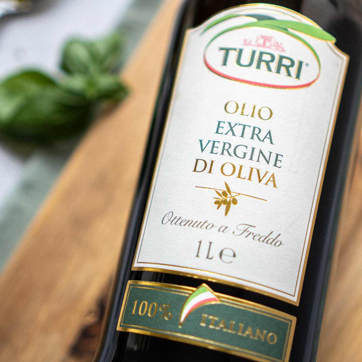 Turri Olivenöl Flasche mit Etikett auf Holzuntergrund.